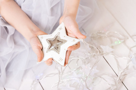 Christmas - children's hands girl holding a starの写真素材