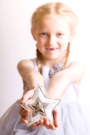 Christmas - children's hands girl holding a star and smilingの写真素材