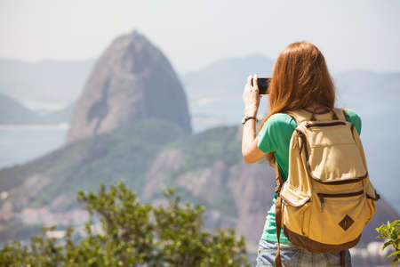 girl tourist taking a photo on a smartphone Pao de Acucar. Rio de Janeiro.の写真素材
