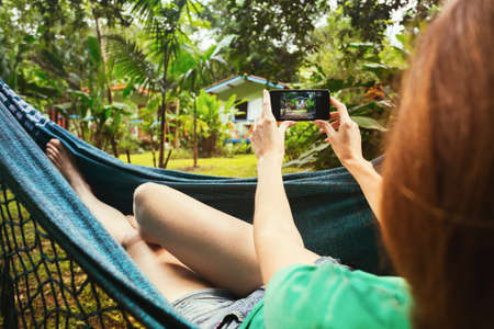 girl lying and  taking a photo in a hammock in the tropical jungles of Brazil. Brasilの写真素材