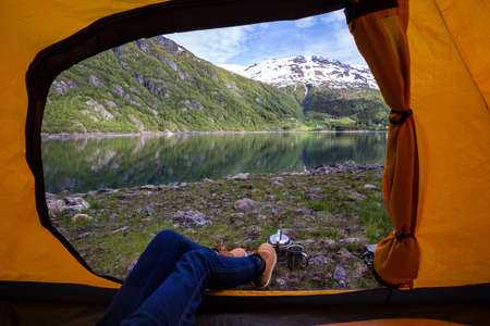 girl hiker in a tent and view of tent on the mountain, norwayの写真素材
