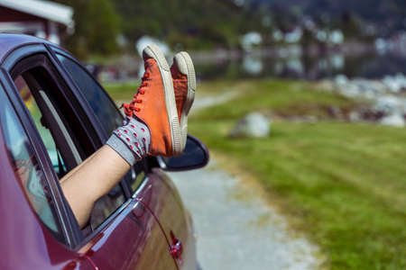 Girl legs in bright sneakers sticking out of the car, norwayの写真素材