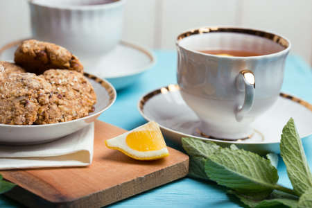 Tea Party -  beautifully decorated table with cups, saucers, tea and oatmeal cookiesの写真素材