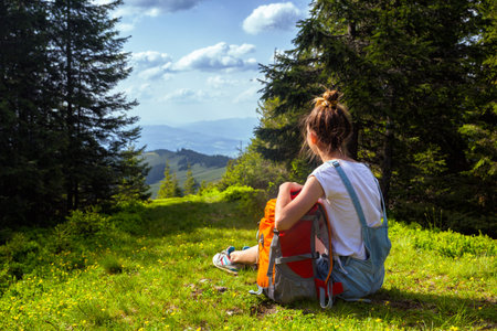 girl hiker with a backpack sitting on the background of mountains and forests. Vorokhta - Ukrainian...