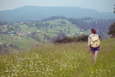 girl hiker with a backpack walking in the mountains. Vorokhta - Ukrainian landscape.