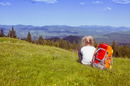 girl hiker with a backpack sitting on the background of mountains and forests. Vorokhta - Ukrainian...