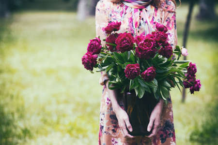 girl holding a jar with a bouquet of peonies
の写真素材