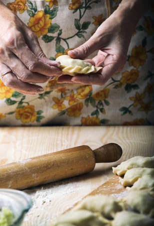 Ukrainian traditional bakery products - Making pierogies by female hands. Rustic style. Retro Photoの写真素材