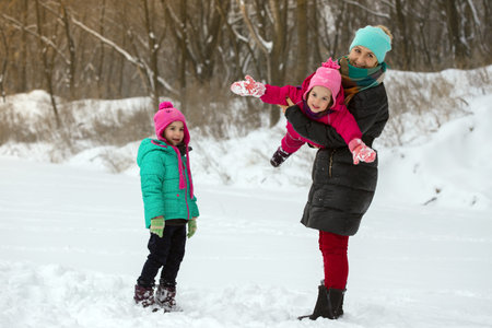 happy family - smiling mother and little daughters at the winter dayの写真素材
