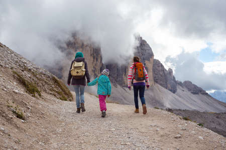 family - mother and two daughters  girls sisters hikers at the mountains Dolomites, Italy. Tre Cime di Lavaredoの写真素材