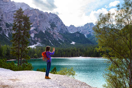 girl hiker taking a photo on a smartphone at the Braies lake, Dolomites Italy
の写真素材