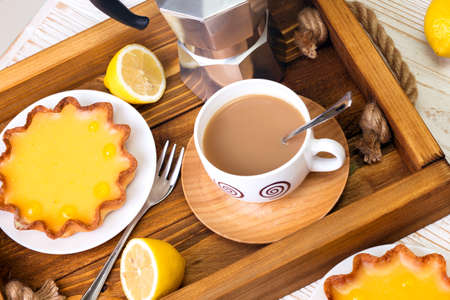 Breakfast - a tray of lemon tarts and coffeeの写真素材