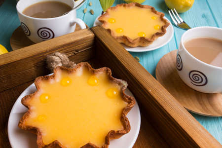Breakfast - a tray of lemon tarts and coffeeの写真素材