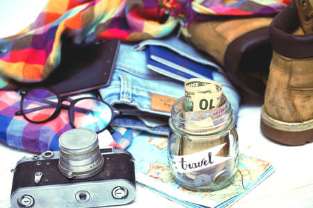 wanderlust. adventure concept. background - what to take for a trip - camera, smartphone, jar with money, glasses, shoes, jeans, accessoriesの写真素材
