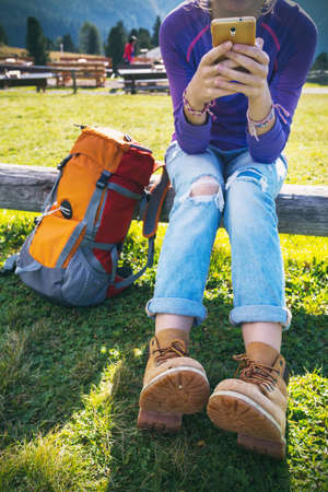 relax - Girl tourist rests with a smartphone at the mountains.  Puez Odle Dolomites,  Italy.の写真素材