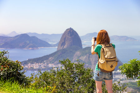 girl tourist taking a photo on a smartphone Pao de Acucar. Rio de Janeiro. Brazilの写真素材