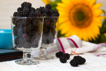 blackberry fruit  in transparent glass on a white wooden tableの写真素材