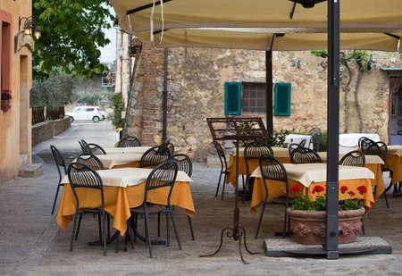 tables and chairs of street cafe at the Italyの写真素材