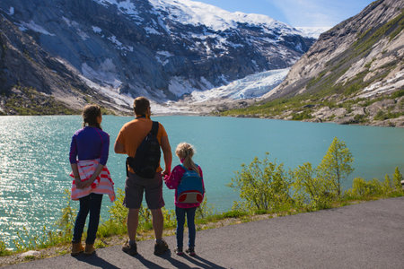 father and children are looking at the Nigardsbreen glacier at Norwayの写真素材