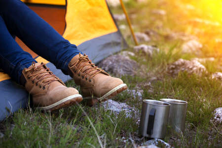 girl hiker in a tent and mountains in the backgroundの写真素材