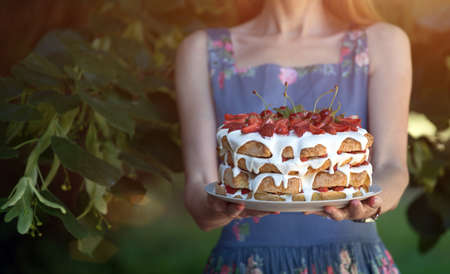 The girl is holding a beautiful biscuit with strawberriesの写真素材