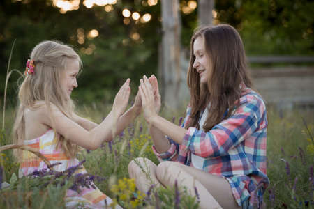summer - Smiling girls sisters playing in a meadowの写真素材