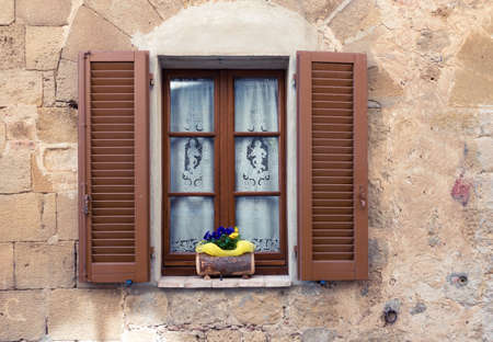 old italian window with the flowers on a window sillの写真素材