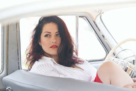 portrait of beautiful girl in a retro car in style pin upの写真素材