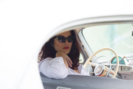 portrait of beautiful girl in a retro car in style pin up