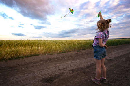 summer - little girl with kite and Ukrainian landscapeの写真素材