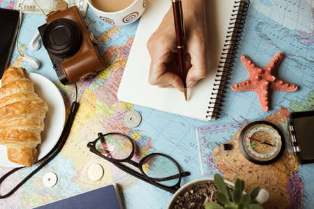 Plan of trip. background - Women's hands and map, retro camera, money, compass,の写真素材