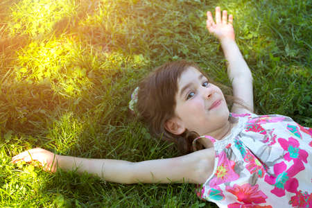 Smiling girl  lying on the grassの写真素材