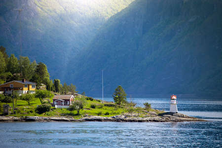 lighthouse and multicolored houses on a fjord shore, norwayの写真素材