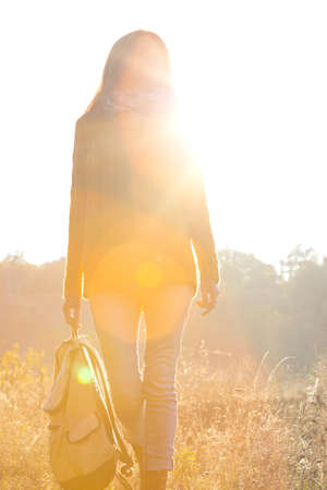 girl walking in the autumn forest at sunset lightの写真素材