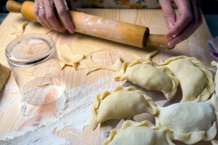 Ukrainian traditional bakery products - Making pierogies by female hands. Rustic style. Retro Photoの写真素材