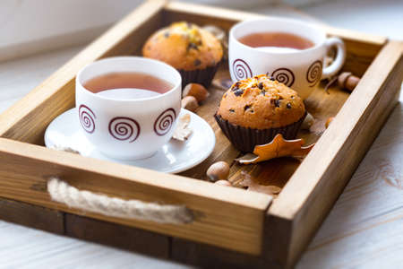 breakfast - cake and cup of tea on a wooden trayの写真素材