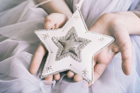 Christmas - children's hands girl holding a starの写真素材