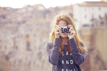 Girl with retro camera talking pictures outdoors, Italy, Pitigliano. Tuscanyの写真素材