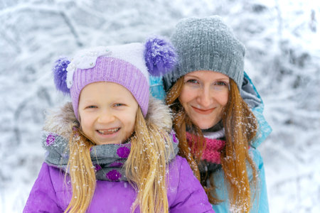 happy family  - mother with smiling daughter on a winter walkの写真素材