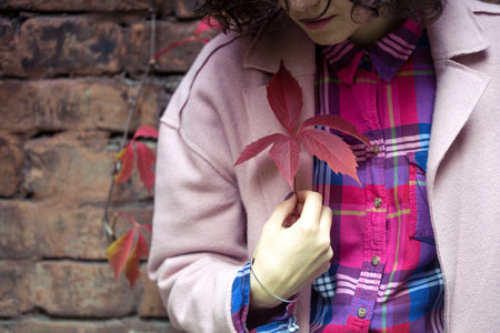 autumn - girl holds a red leaf