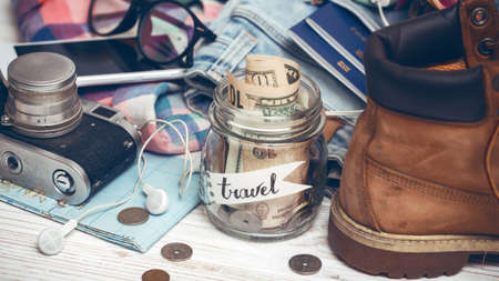 wanderlust. adventure concept. background - what to take for a trip - camera, smartphone, jar with money, glasses, shoes, jeans, accessoriesの写真素材