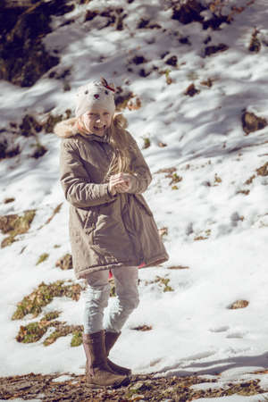 little smiling girl outdoors at the snowfall timeの写真素材