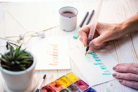 girl makes the inscription watercolor -  hello weekend
の写真素材
