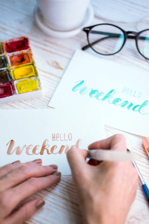 girl makes the inscription watercolor -  hello weekendの写真素材