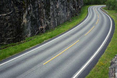 empty winding forest road at the mountainsの写真素材