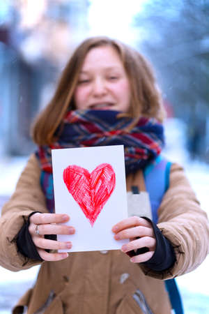 happy teen girl holding drawing with a heart on the valentines day
の写真素材