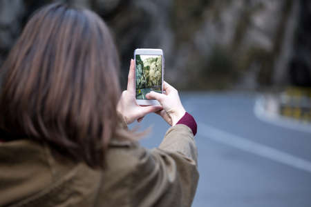 girl taking a photo on a smartphone in the Cheile Bicazului,  Romaniaの写真素材
