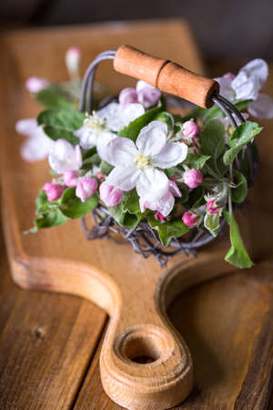 Spring. branches of a blossoming apple-tree in a basket on a wooden background
の写真素材