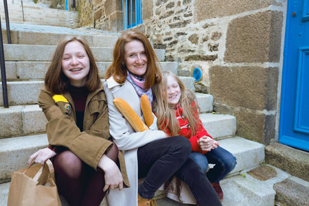 French happy smiling mother with baguettes and daughters