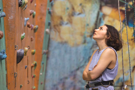 Bouldering, beautiful girl look on the climbing wall. Assessment of their capabilities.の写真素材